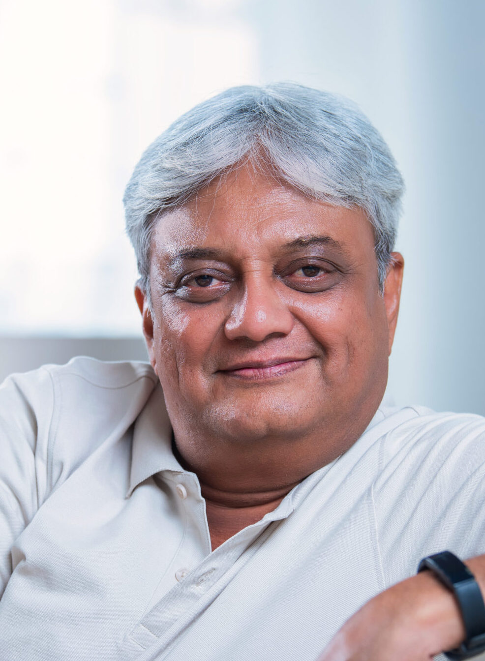 indian asian happy senior retired couple sitting on sofa or couch in living room spending quality time